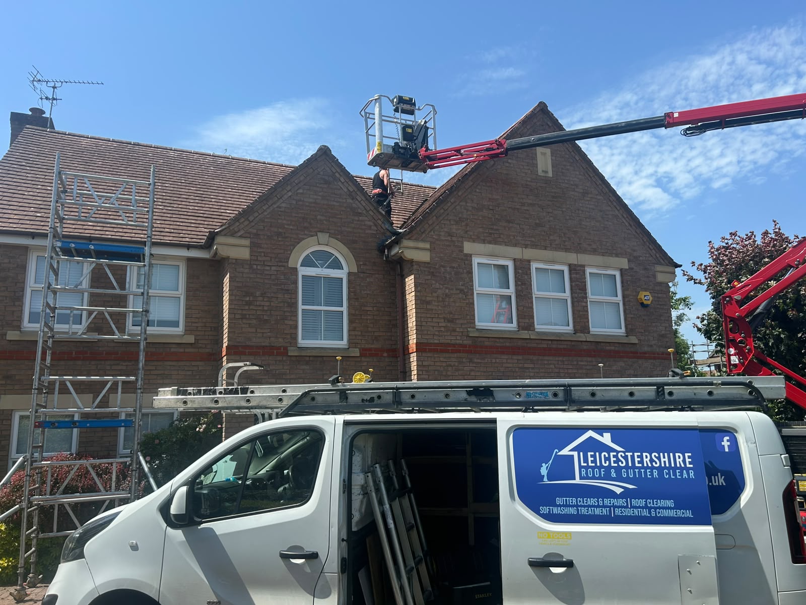 Tracked spider lift and the Leicestershire Roof & Gutter Clear van at a residential property on a sunny day